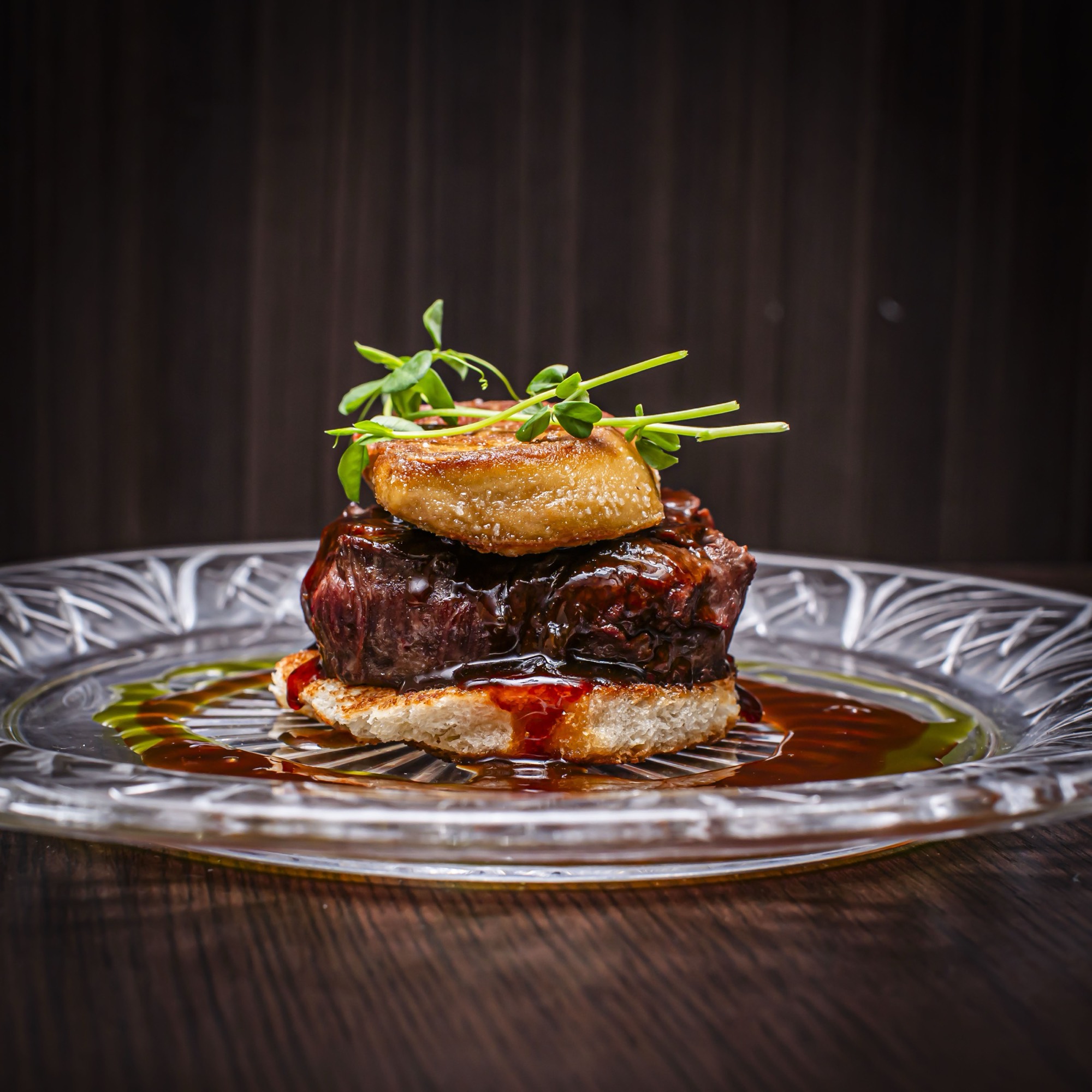 Short rib with foie gras and herbs on a crystal plate
